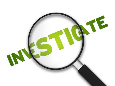 Magnifying Glass with the word Investigate on white background.